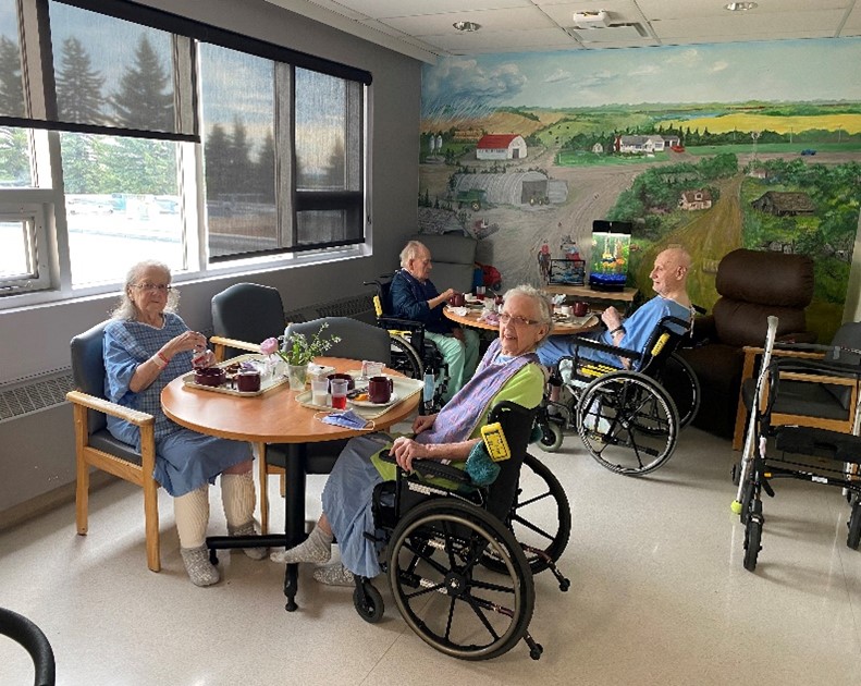 Vegreville BREATHE patients eat lunch together around two tables.